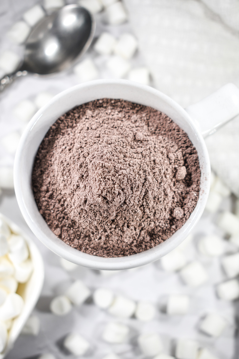 a mug of hot cocoa mix surrounded by marshmallows
