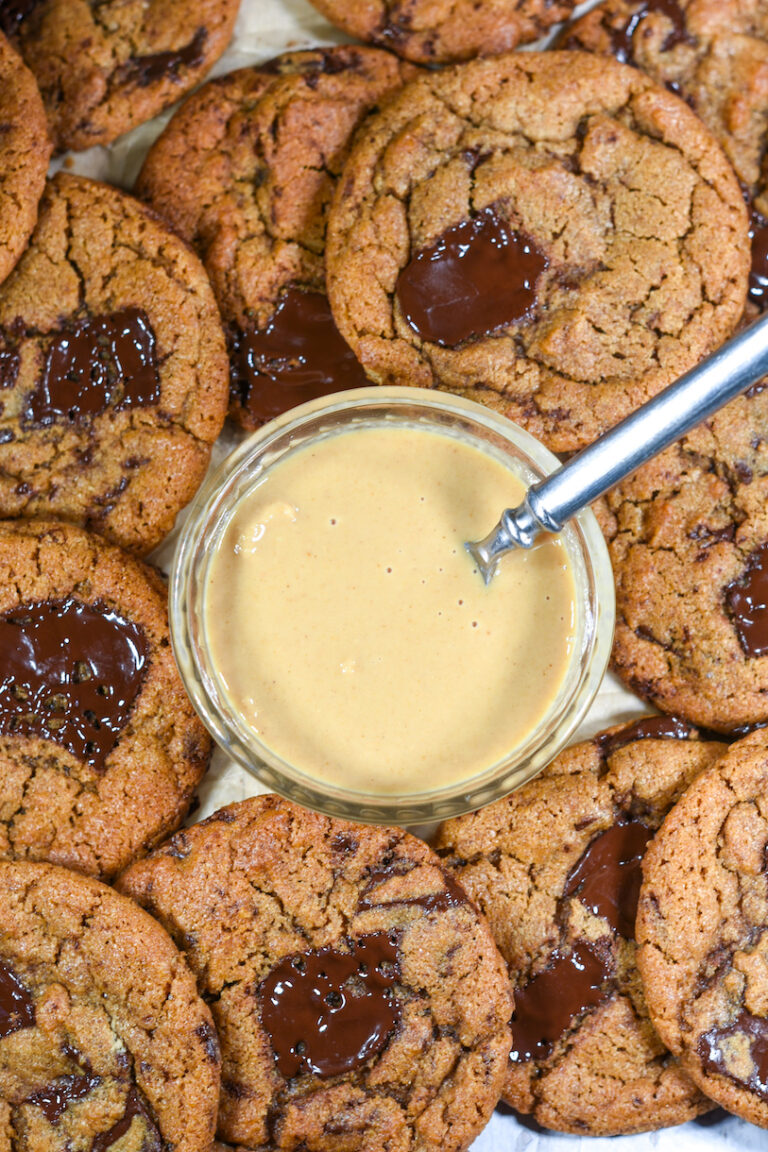 An easy chocolate chunk tahini cookies recipe comprised of brown sugar, chopped dark chocolate, and tahini, a Middle Eastern condiment made from ground toasted sesame seeds. The tahini lends a nutty note (similar to peanut or almond butter) which pairs perfectly with dark chocolate. These soft, bakery style tahini chocolate chip cookies are easy to prepare and absolutely delicious.