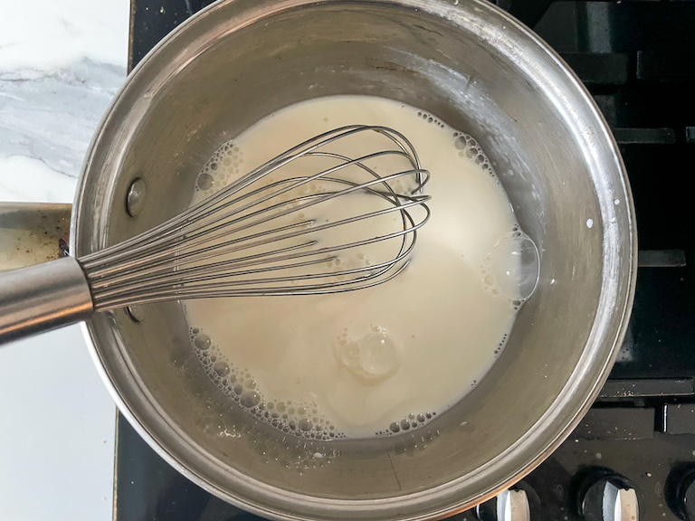 whisk in a bowl with whole milk