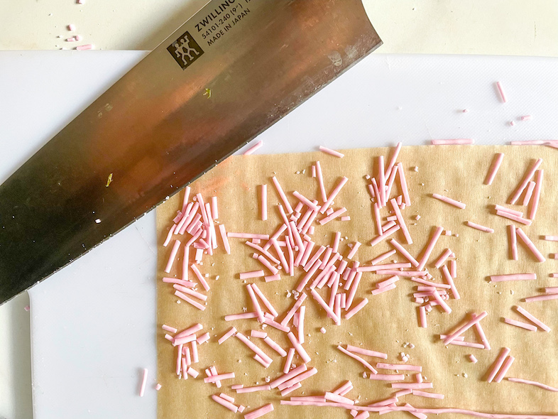 Knife cutting pink homemade sprinkles