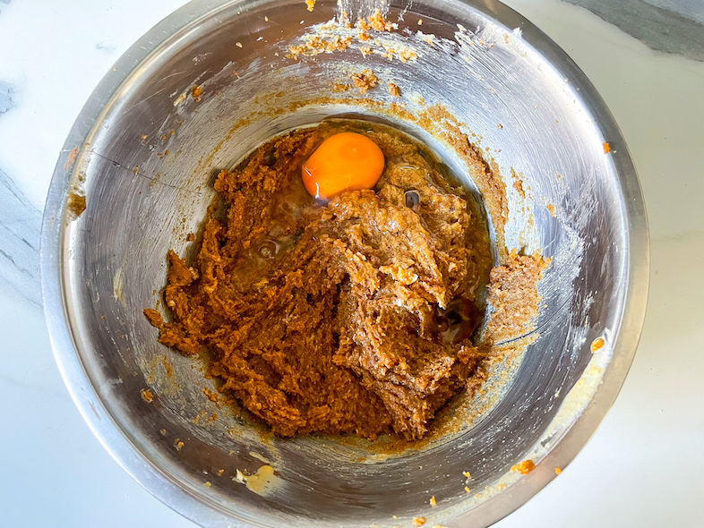 Adding egg to the batter for chocolate tahini cookies
