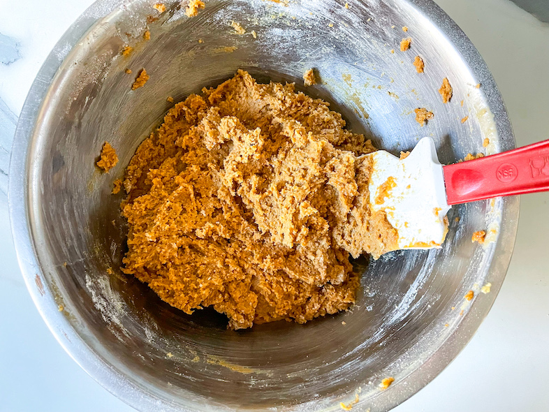 batter for tahini chocolate chunk cookies in a bowl with a spatula