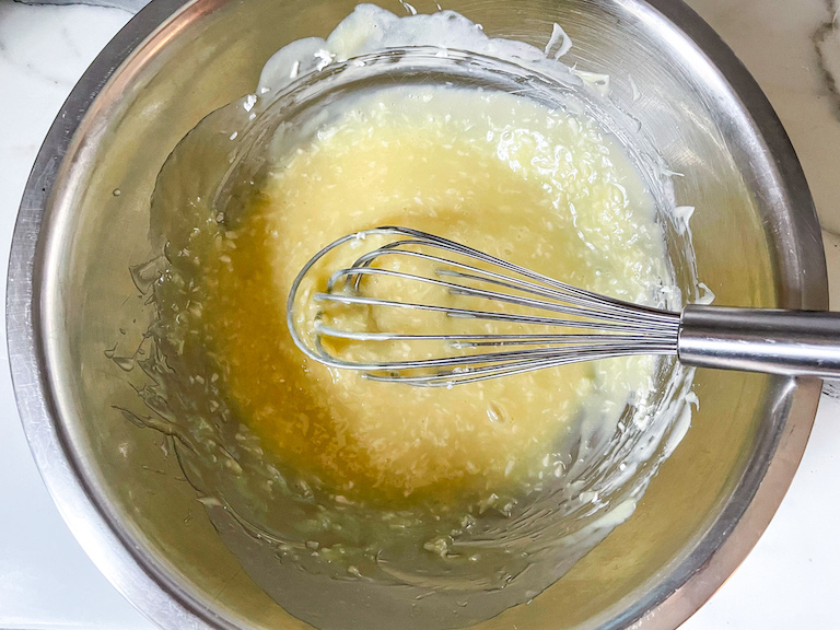 Bowl of melted white chocolate with a whisk