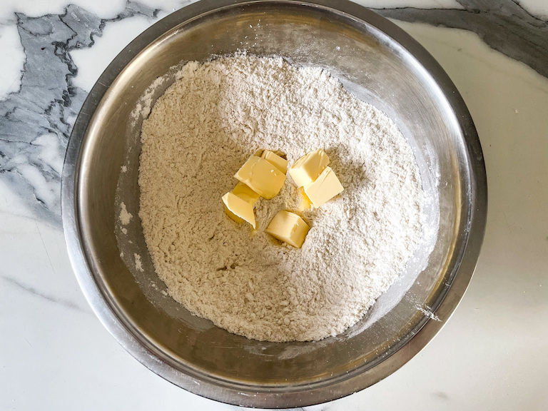 Butter cubes in a bowl of flour