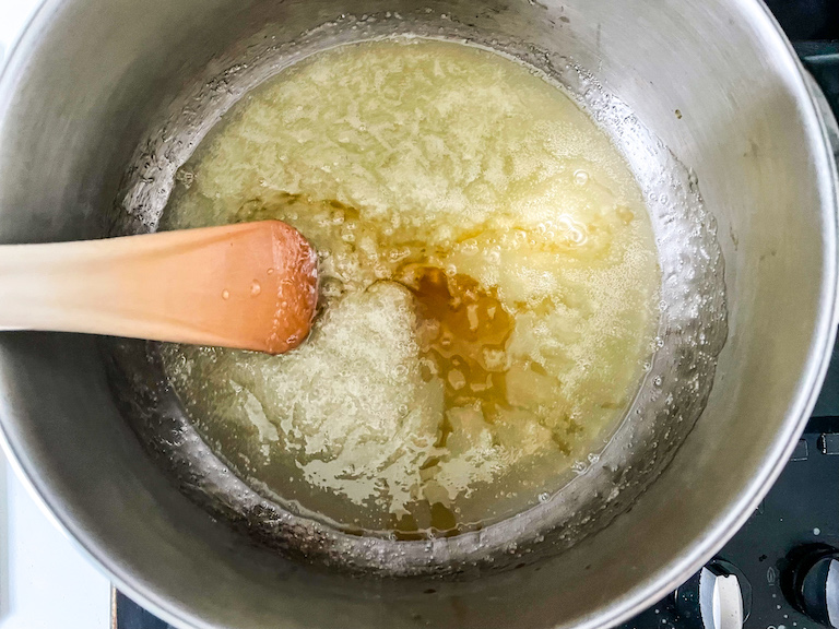 Stirring vanilla into homemade candy corn mixture