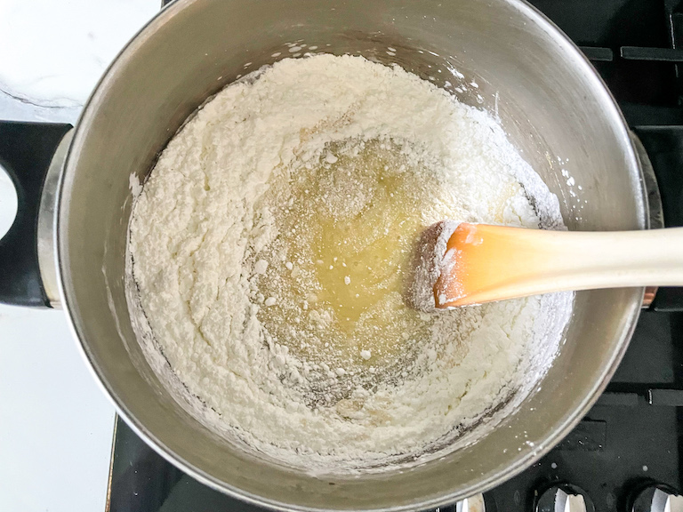 Spoon stirring powdered sugar into candy corn batter