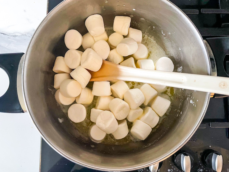 Butter, marshmallows, and a spoon in a large pot