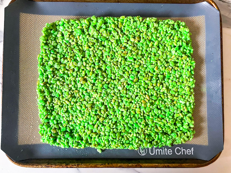 Green rice krispies arranged in a rectangle on a silicone mat