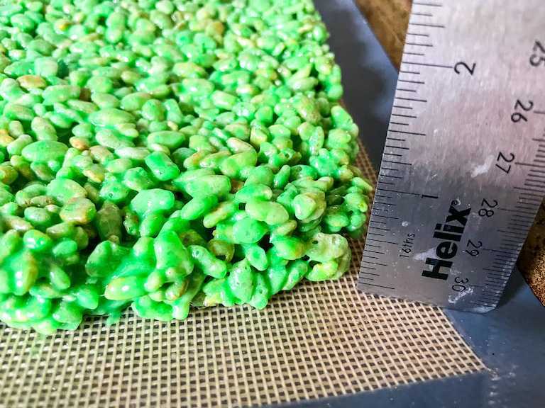 A ruler measuring a square of green rice krispies
