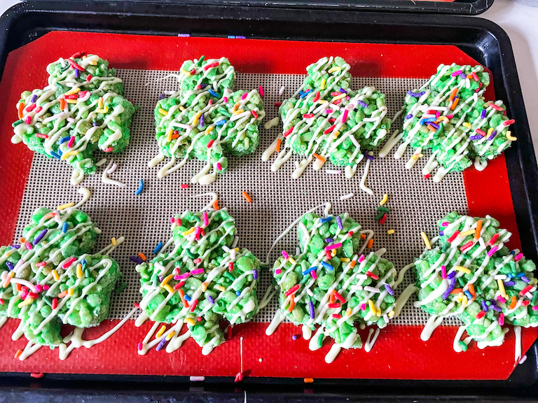 Shamrock rice krispie treats with melted white chocolate and rainbow sprinkles