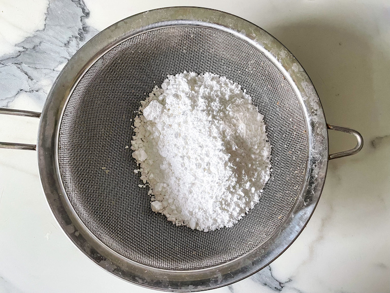 Sifting confectioner's sugar in a mesh sieve