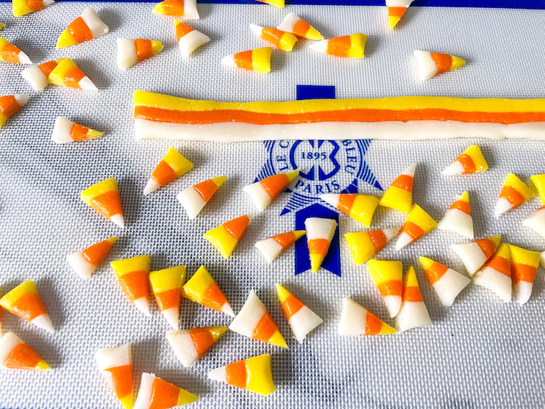 Triangles of homemade candy corn on a silicone mat