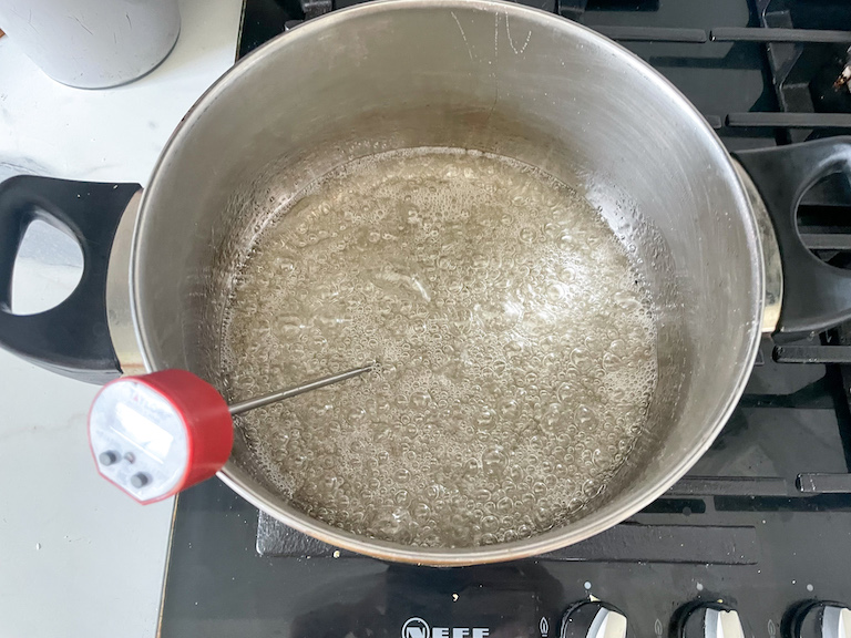Boiling sugar in a pot with a candy thermometer