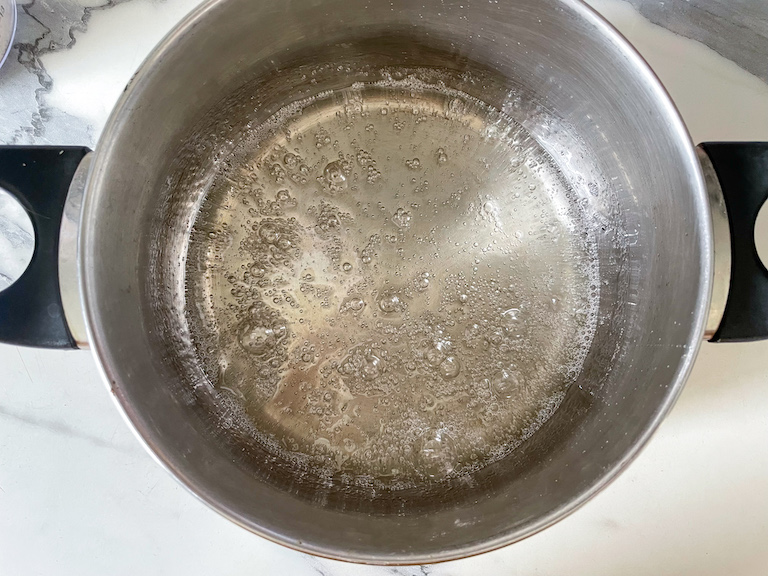 Boiling sugar in a pot on marble countertop