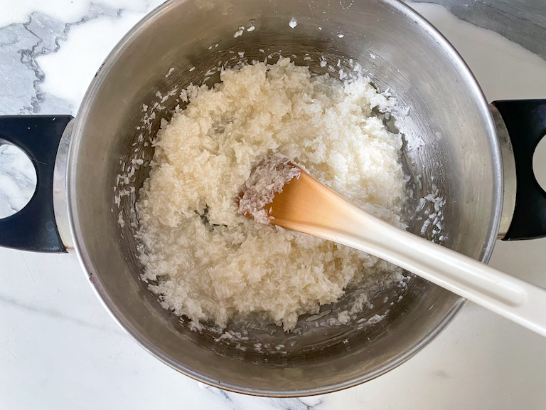 Stirring coconut into hot sugar mixture