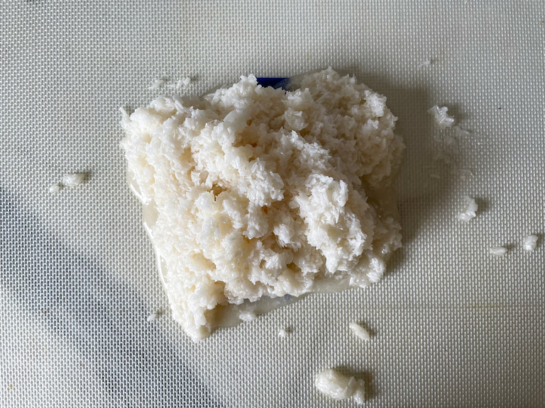 Cooked coconut candy mixture on a silicone mat