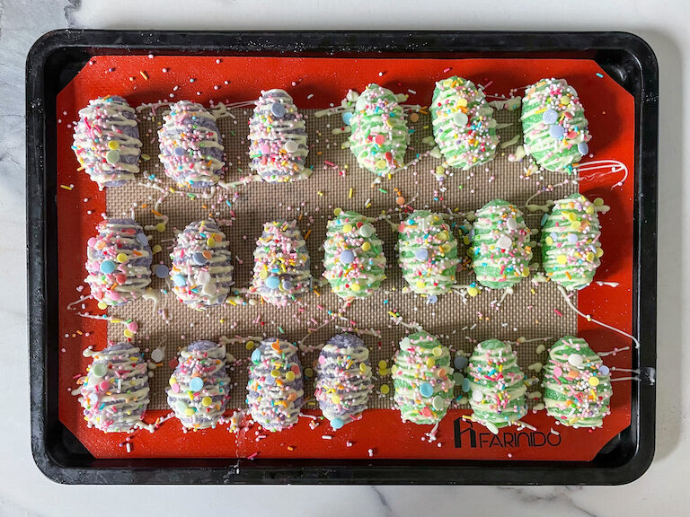 Chewy coconut candy eggs decorated with white chocolate and sprinkles, on a small tray