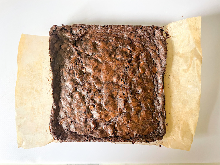 A slab of brownies on a sheet of parchment