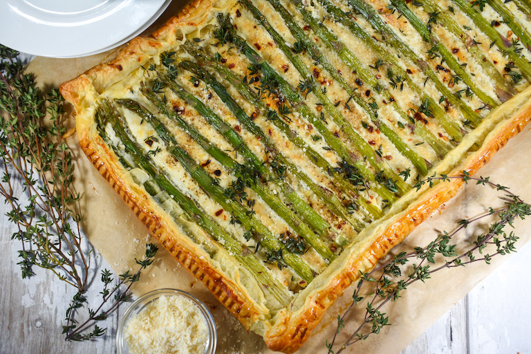 Asparagus and cheese tart, thyme sprigs, and bowl of cheese