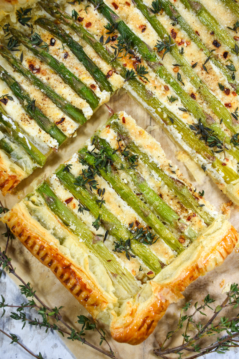 Closeup shot of a square of goat cheese and asparagus tart