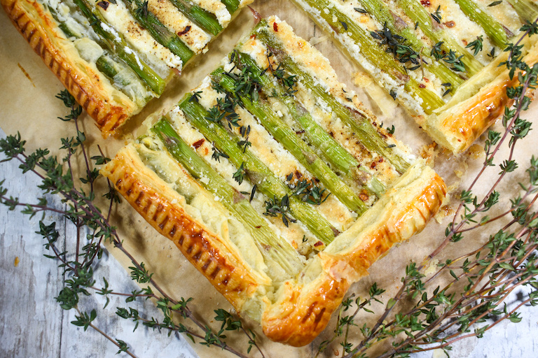 Asparagus goat cheese tart slice surrounded by thyme leaves