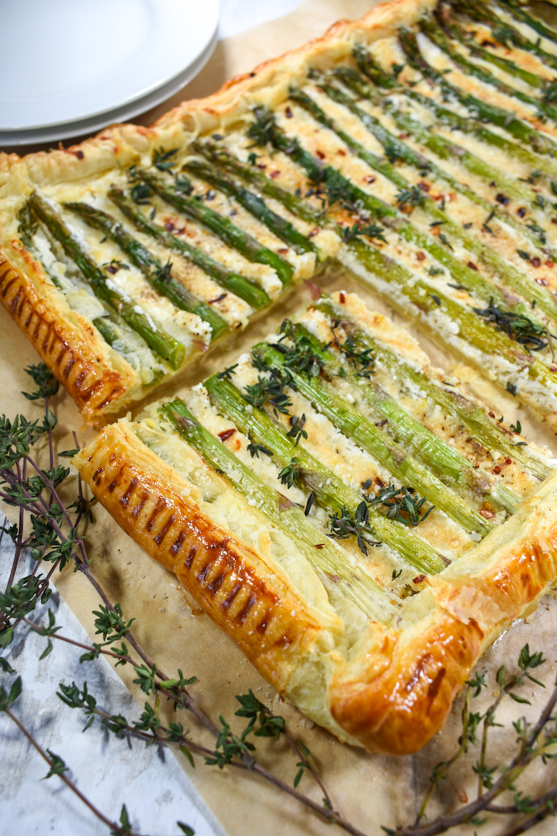 Square of goat cheese and asparagus tart with sprigs of thyme