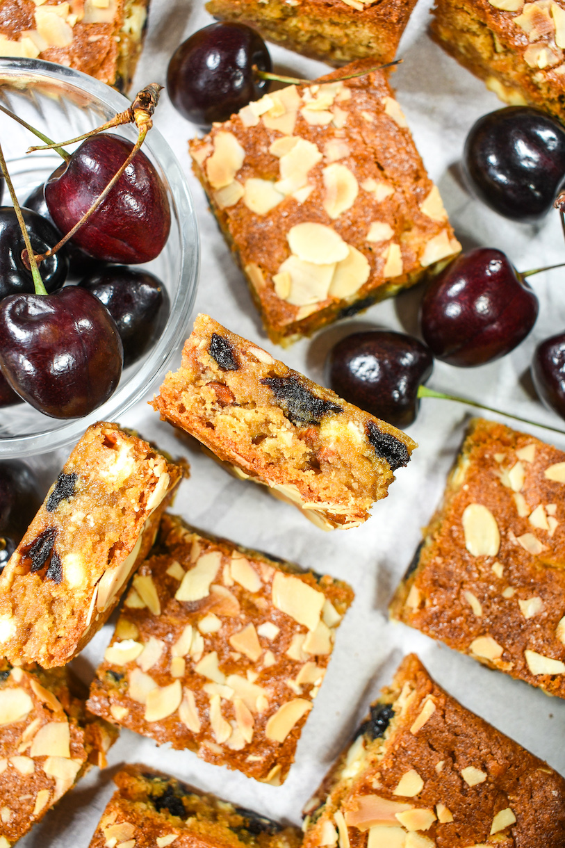 Blondies arranged on a white surface with cherries