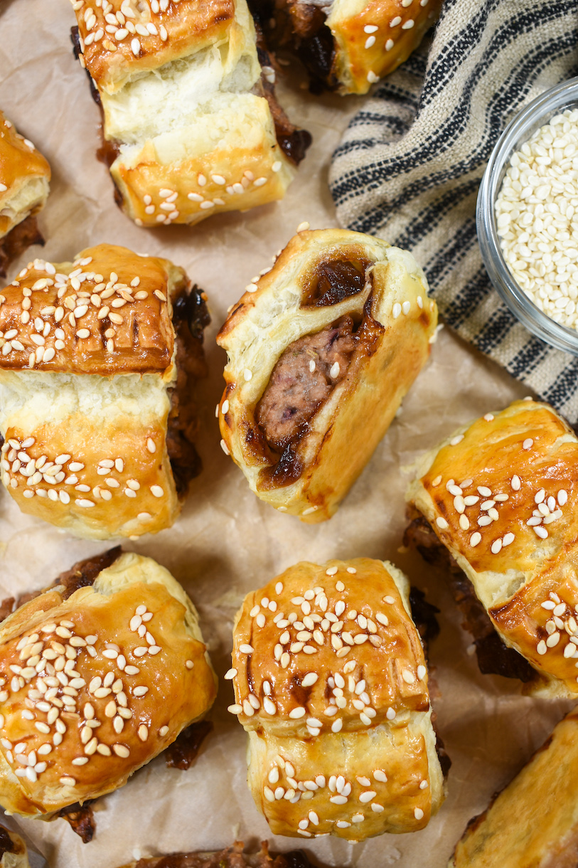 Looking down at vegetarian sausage rolls arranged on a sheet of brown parchment