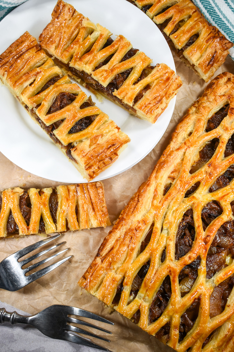 Caramelized onion puff pastry tart and slices of pastry on a white plate