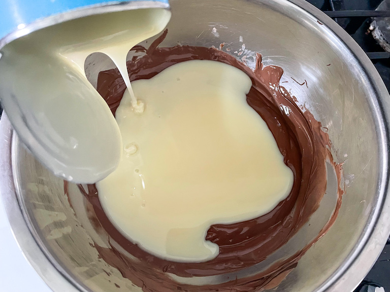 Pouring condensed milk into chocolate