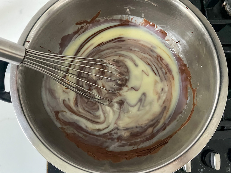 Whisking condensed milk into chocolate for three ingredient fudge