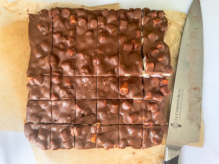 A slab of 3 ingredient fudge cut into squares, and a knife