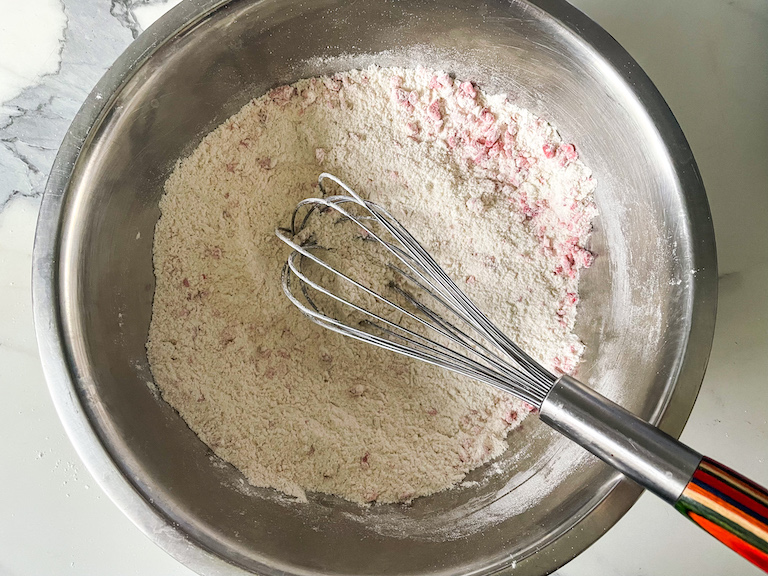 A bowl of dry ingredients and a whisk