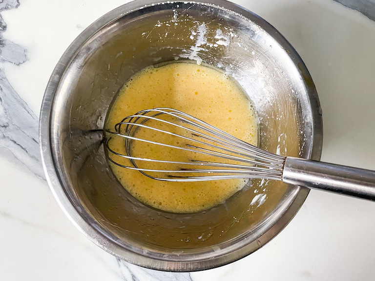 Wet ingredients in bowl with a whisk