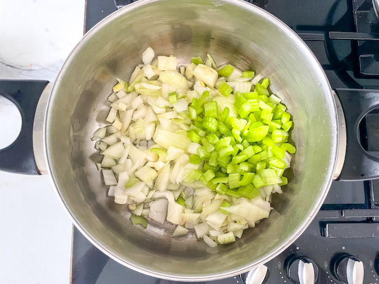 Chopped celery and onions in a pot on the stovetop