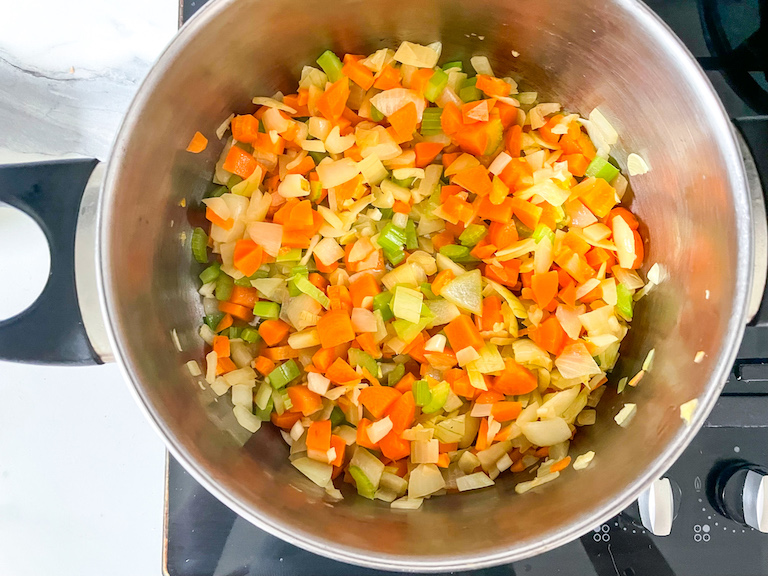Chopped carrots, celery, and onions in a stock pot on stovetop