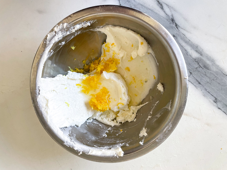 A metal bowl with goat cheese and lemon zest