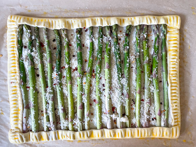 Unbaked asparagus goat cheese tart with chili flakes