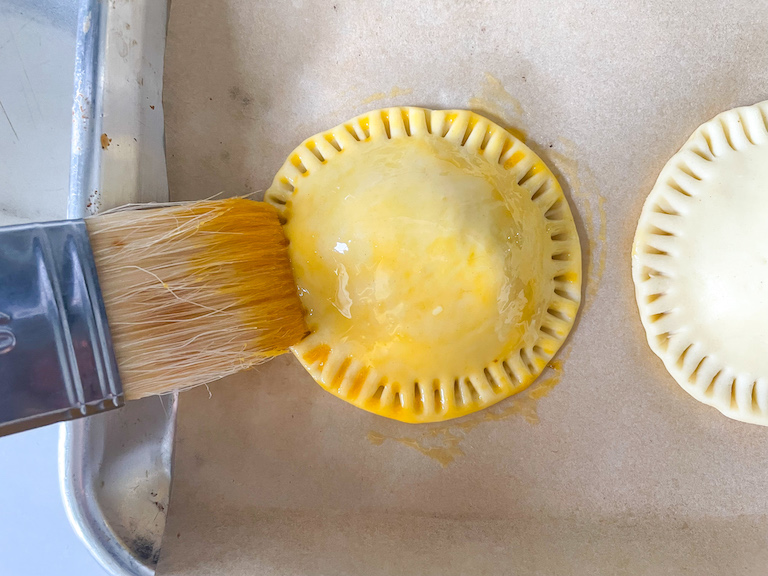 Brush applying egg wash to shortcrust pastry