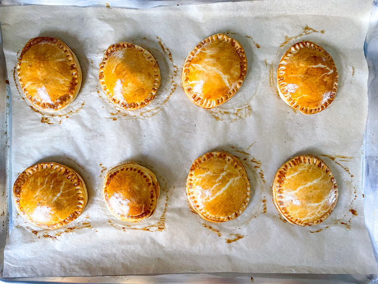 Baked hand pies on a parchment lined tray