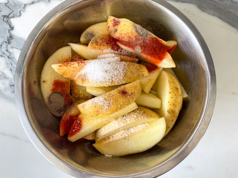 Potato wedges in a bowl with spices