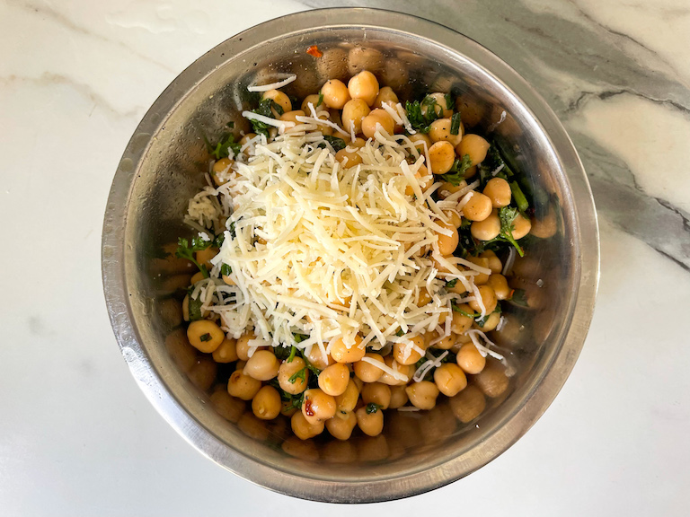Grated cheese on top of a bowl of garbanzo bean salad