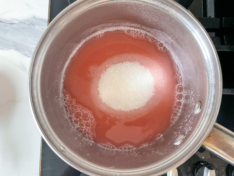 Saucepan with rhubarb water and sugar