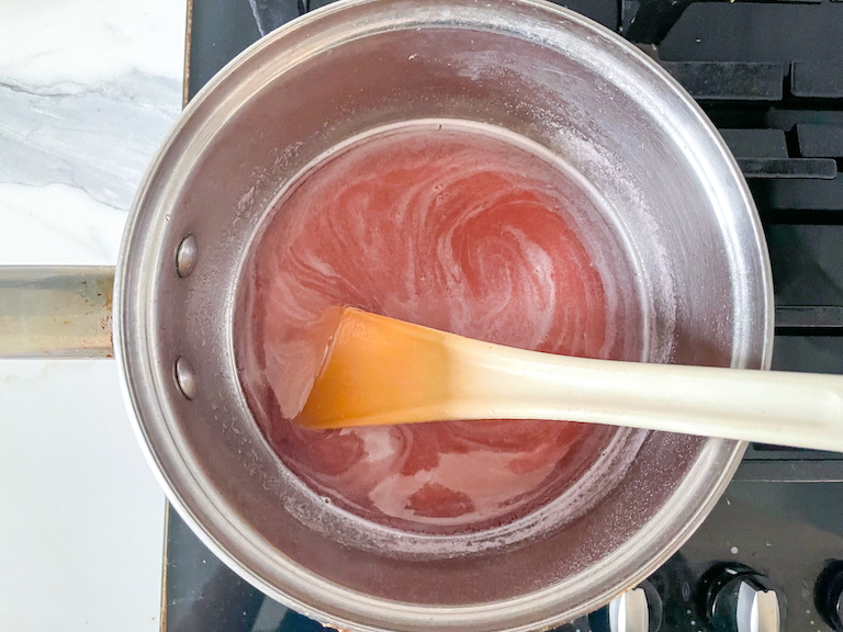 Saucepan with a spoon stirring rhubarb simple syrup