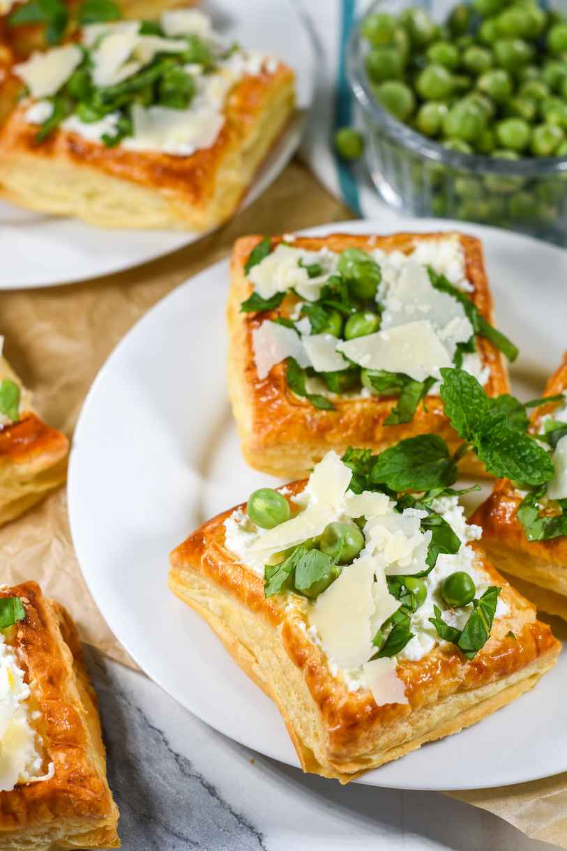 Plate of puff pastry tartlets with sprig of fresh mint on top