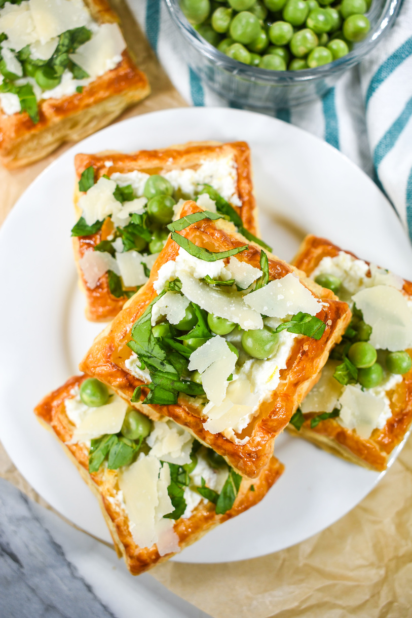Looking down at a plate of puff pastry tarts with ricotta peas and mint