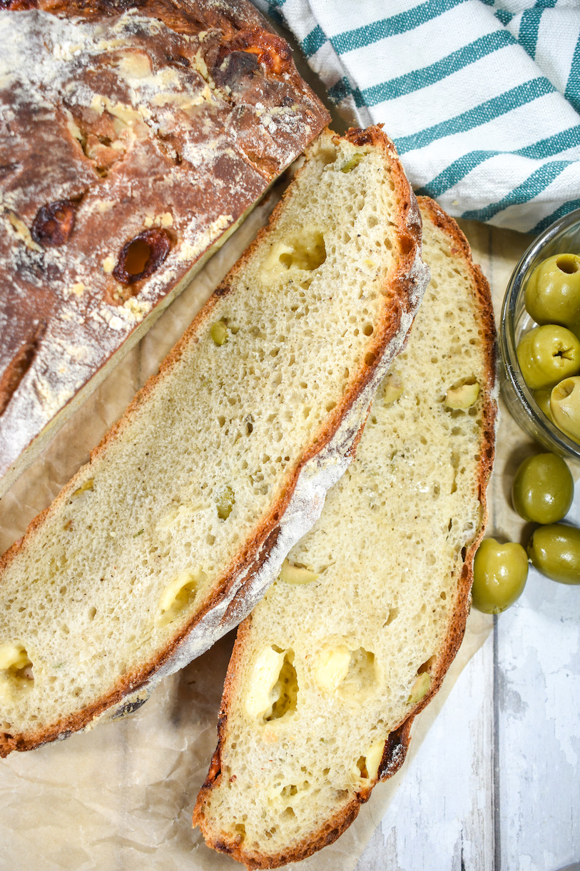 Sliced olive cheese bread and a dish of olives