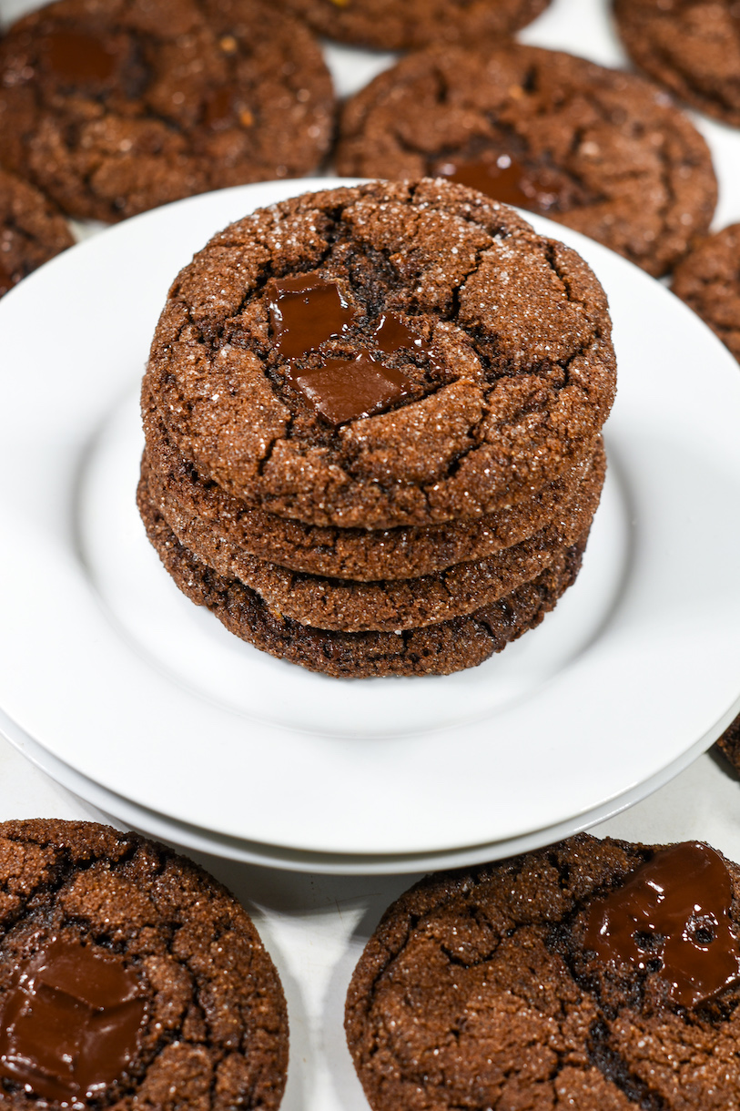 A stack of four ginger molasses cookies on a white plate