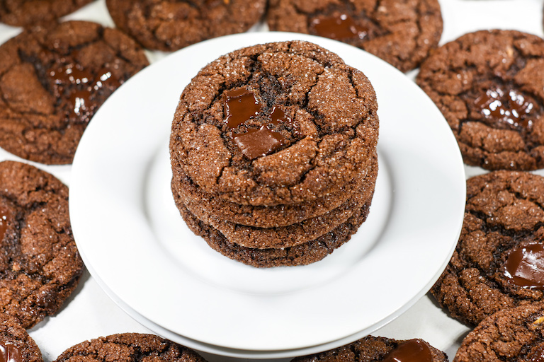 A stack of molasses cookies on a white plate
