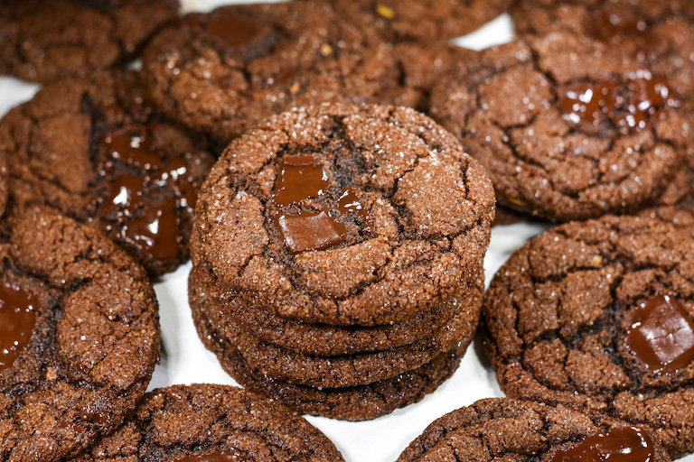 Stack of soft molasses cookies with chunks of chocolate
